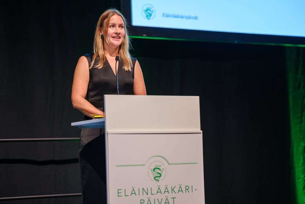 Venla Jyrkinen seisoo puhujan korokkeella lavalla, Eläinlääkäripäivien avajaisissa.